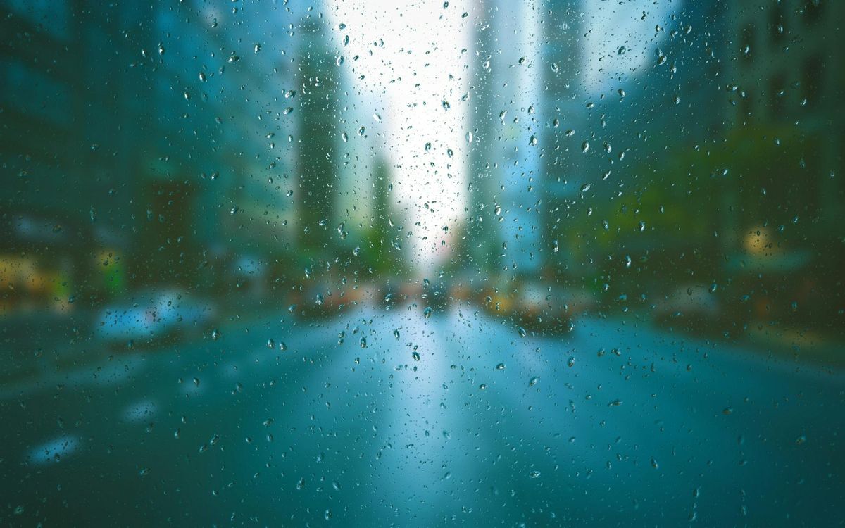 Rain on a glass surface over an out-of-focus city street representing fragmented visibility across the organization