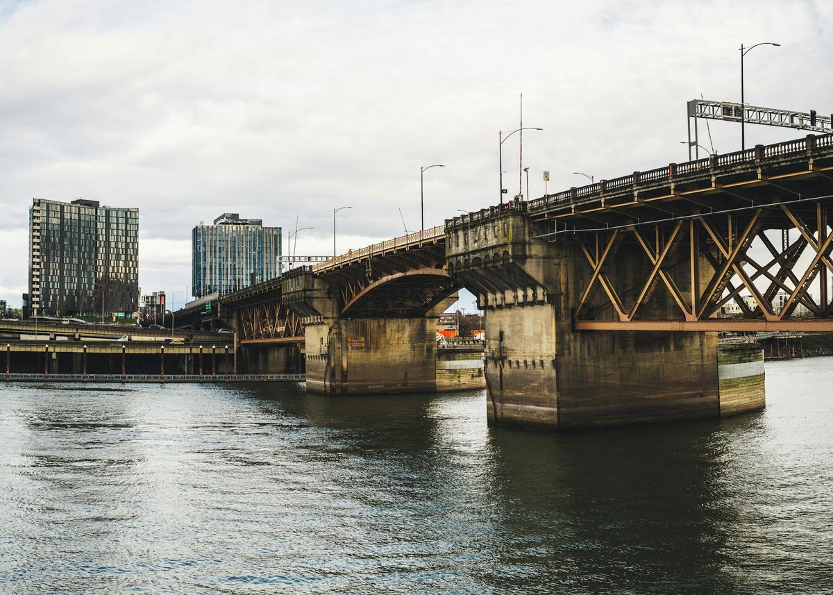 Bridge spanning a river into the city representing one connected delivery path across functions and phases