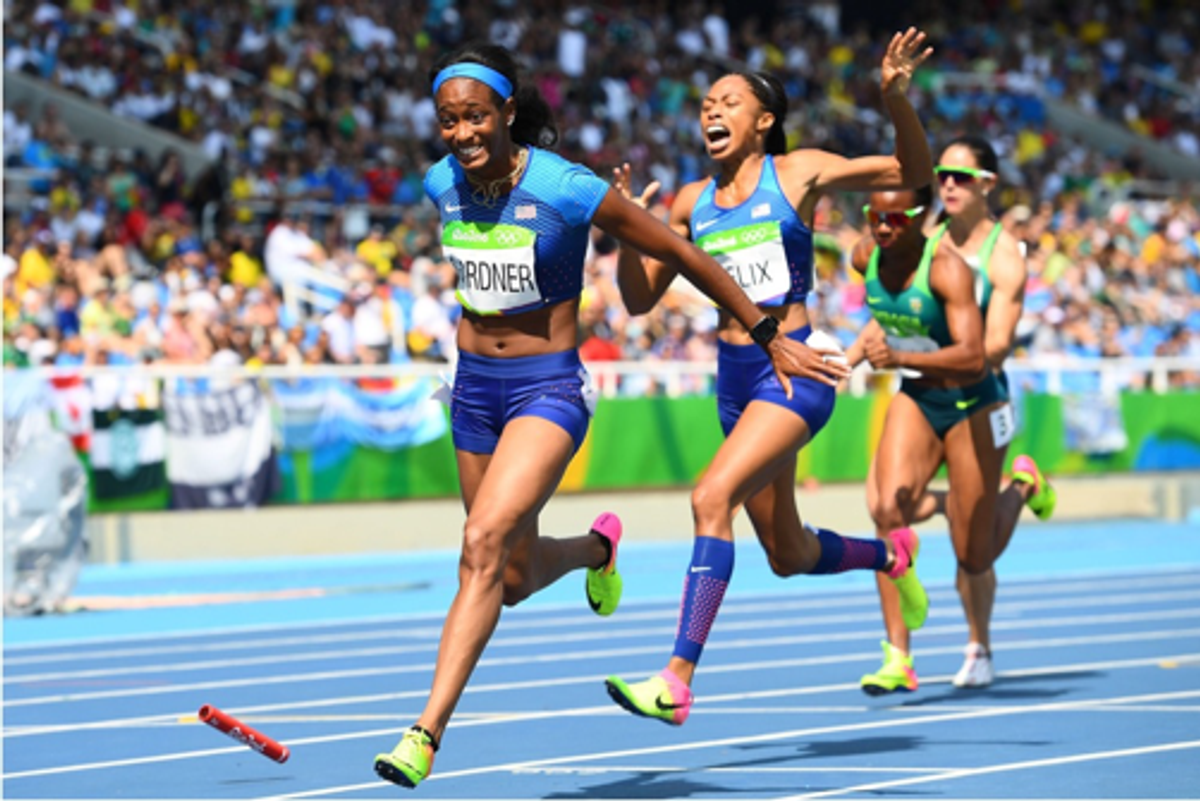 Relay runners in a 4x race converging on the baton on the track