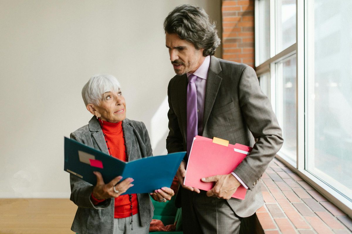 Senior principal and female executive in a one-on-one discussion reviewing priorities
