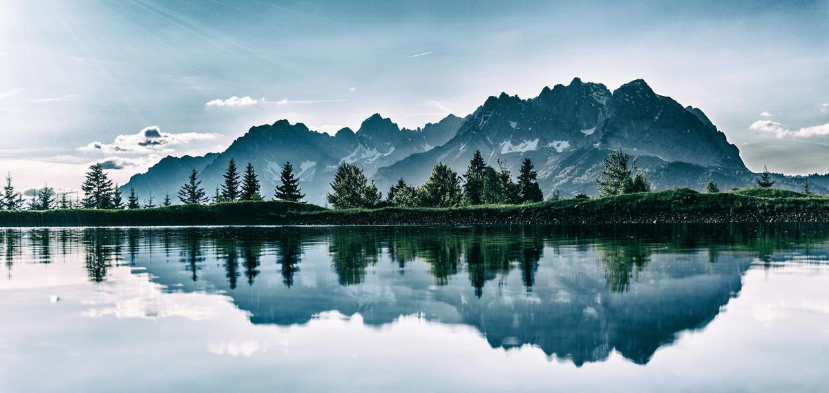 Mountain range reflected in still water representing clarity, alignment, and stable long-term direction